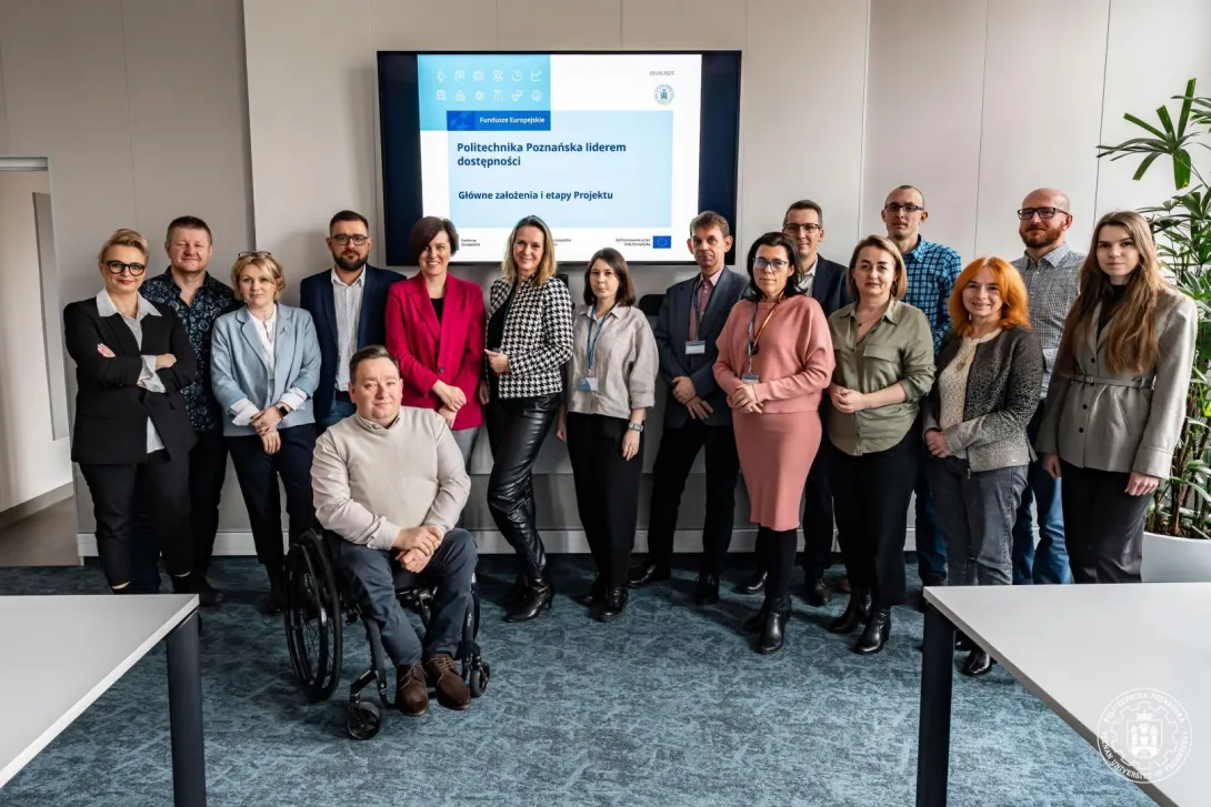 Zespół ds. Dostępności w pełnym składzie na tle prezentacji. Zdjęcie zrobione podczas otwarcia projektu